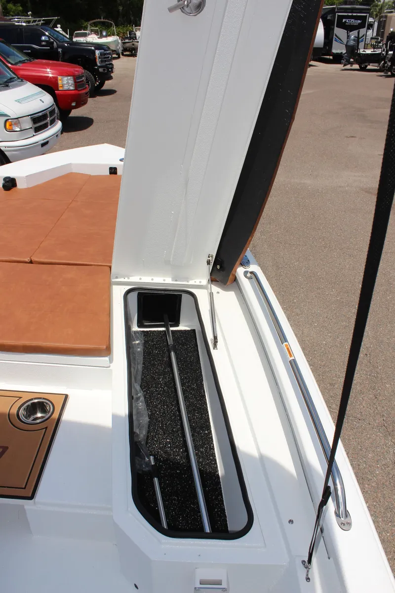 Slide: The Image of 2024 Avid 21 Fusion boat storage compartment with open lid. - 27