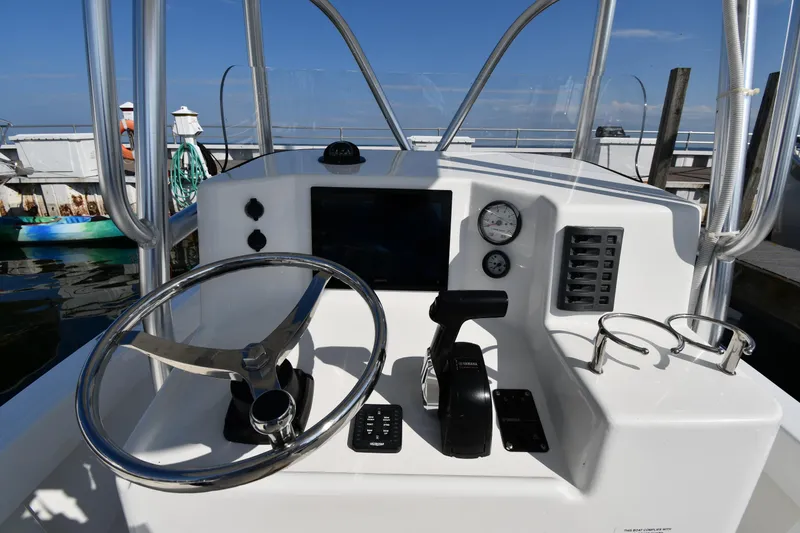 Slide: The Image of 2021 Eastern 248 Center Console boat helm with steering wheel and control panel. - 10