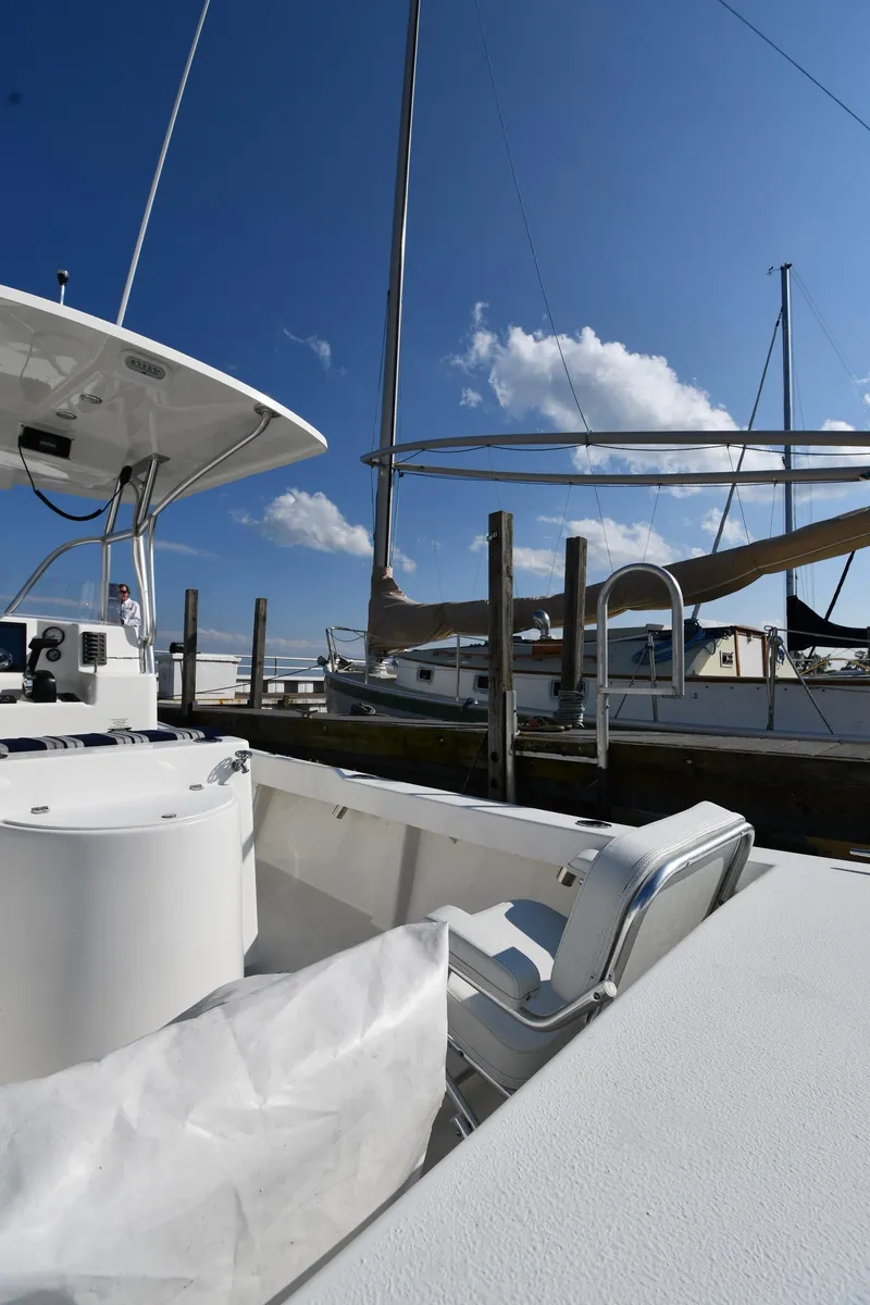 Slide: The Image of 2021 Eastern 248 Center Console boat docked at a marina under a clear blue sky. - 15