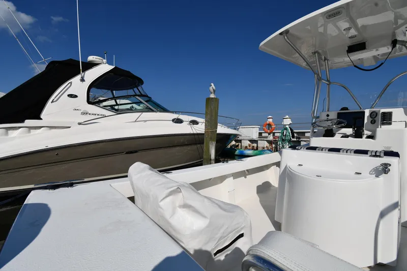 Slide: The Image of 2021 Eastern 248 Center Console boat docked near another vessel on a sunny day. - 16