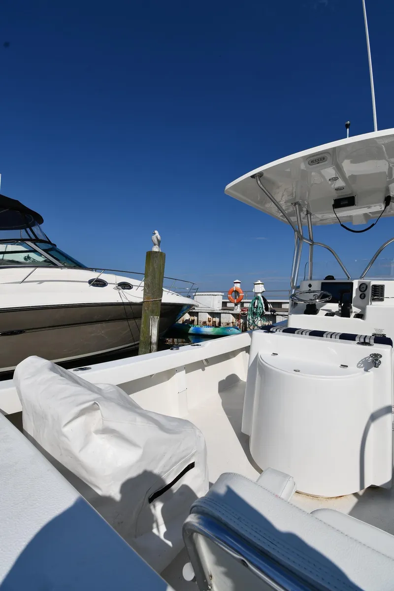 Slide: The Image of 2021 Eastern 248 Center Console boat docked at a marina on a sunny day. - 17
