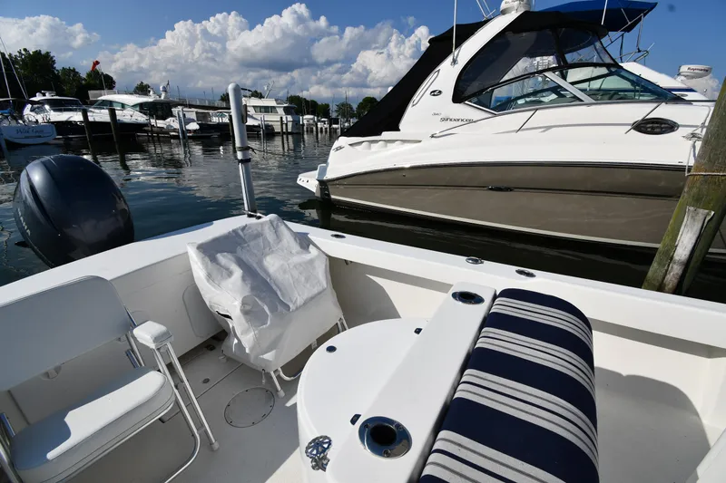 Slide: The Image of 2021 Eastern 248 Center Console boat docked at a marina with other boats. - 18