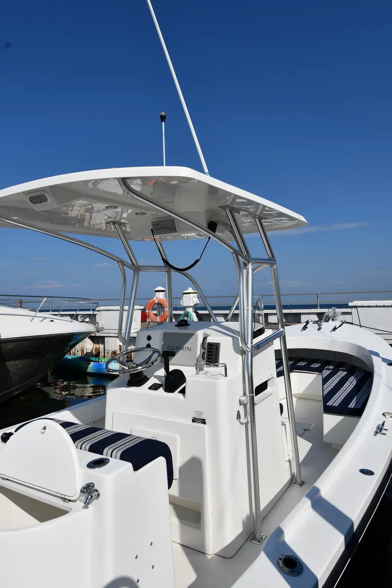 Slide: The Image of 2021 Eastern 248 Center Console boat docked under clear blue sky. - 2