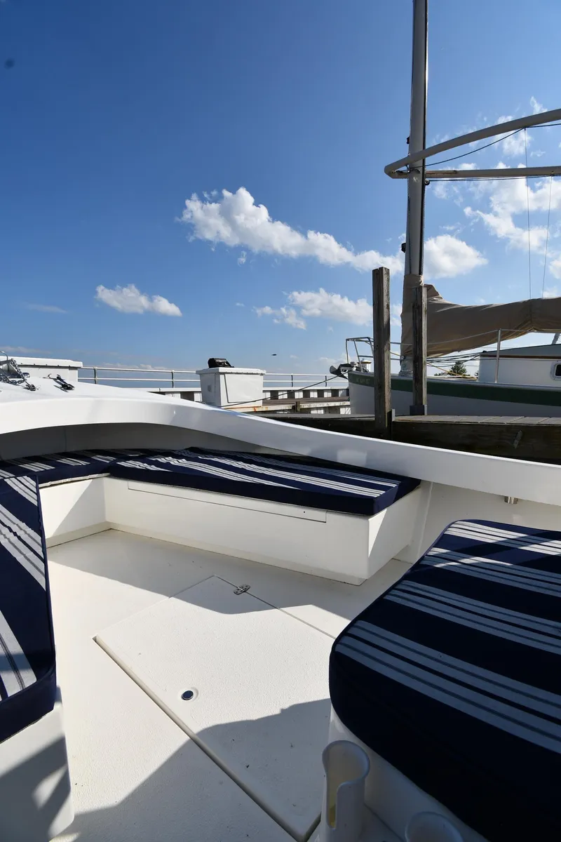 Slide: The Image of 2021 Eastern 248 Center Console boat with striped seating, docked under a clear blue sky. - 21
