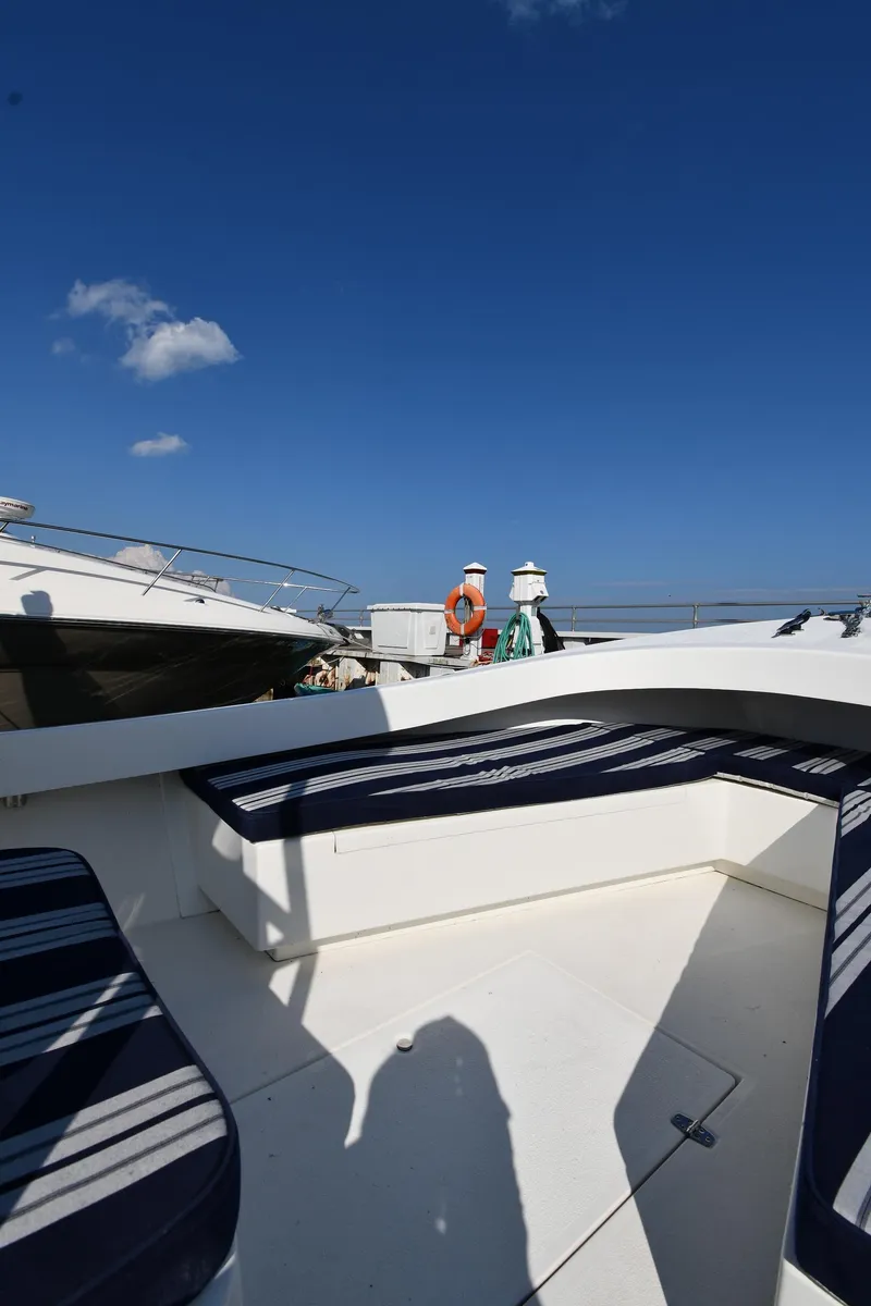 Slide: The Image of 2021 Eastern 248 Center Console boat with blue-striped seating under a clear blue sky. - 23