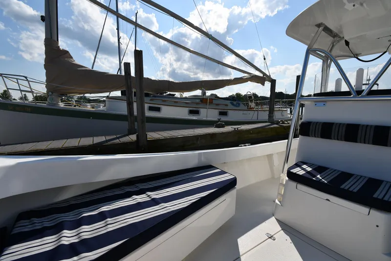 Slide: The Image of 2021 Eastern 248 Center Console boat interior with striped seating at marina. - 25