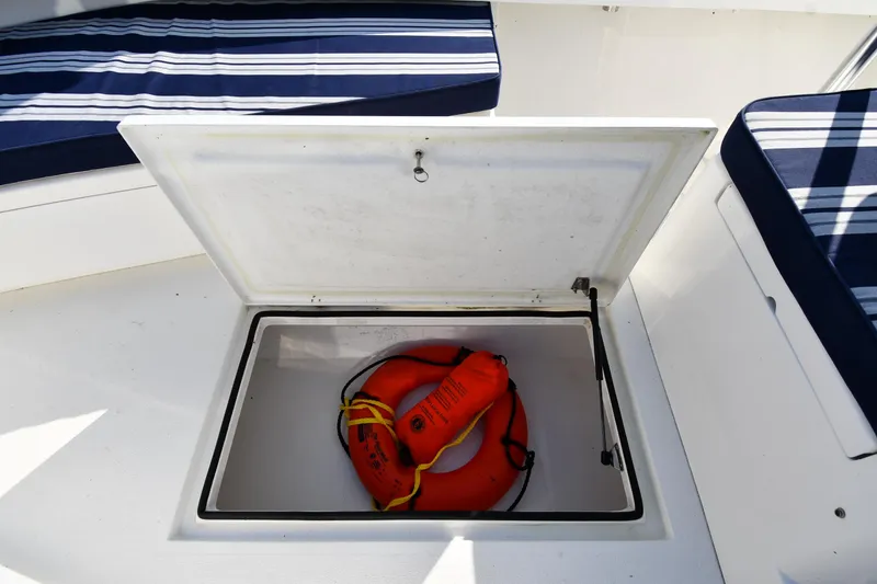 Slide: The Image of Open storage compartment on 2021 Eastern 248 Center Console boat with life ring. - 29