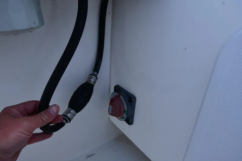 Slide: The Image of Hand holding a fuel line in a 2021 Eastern 248 Center Console boat. - 32