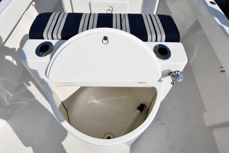 Slide: The Image of 2021 Eastern 248 Center Console boat with open storage compartment and striped cushion. - 36