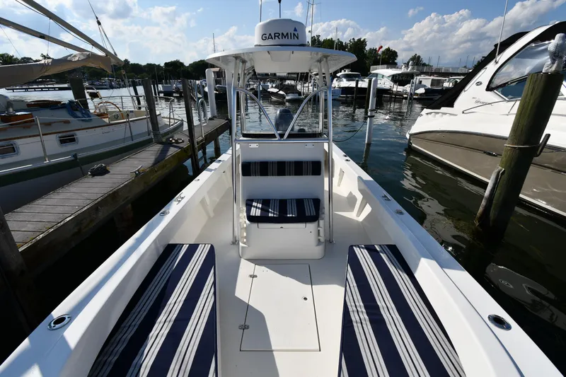 Slide: The Image of 2021 Eastern 248 Center Console boat docked, featuring striped seating and Garmin navigation. - 4
