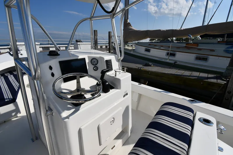 Slide: The Image of 2021 Eastern 248 Center Console boat interior with steering wheel and striped seating. - 8