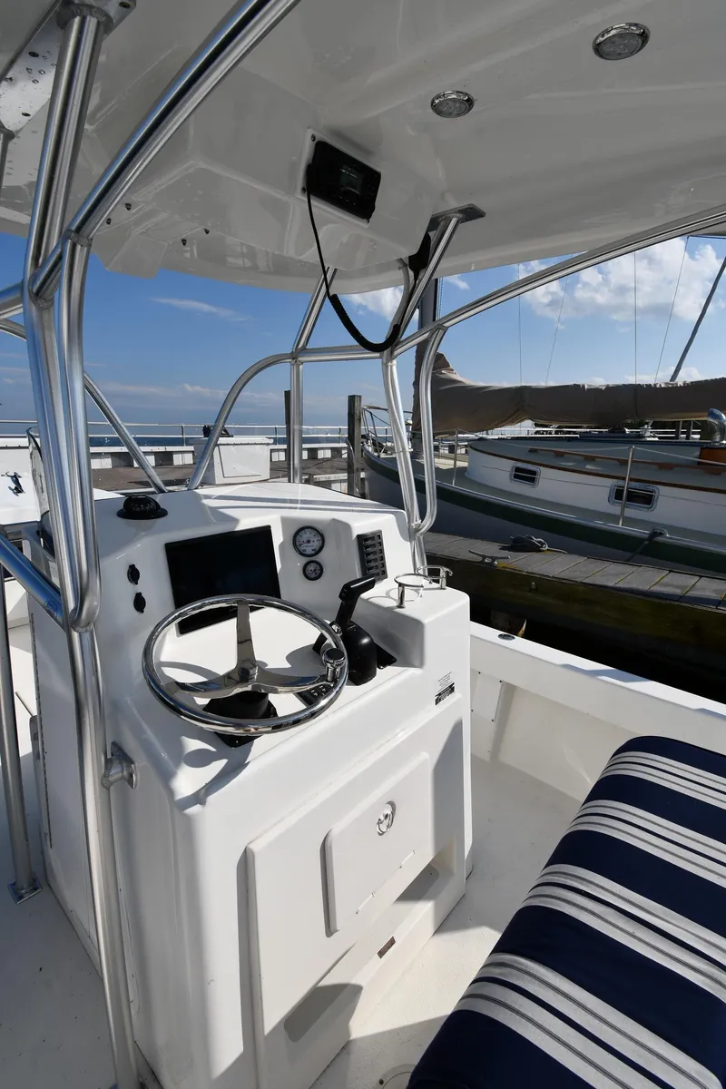 Slide: The Image of 2021 Eastern 248 Center Console boat interior with steering wheel and striped seating. - 9