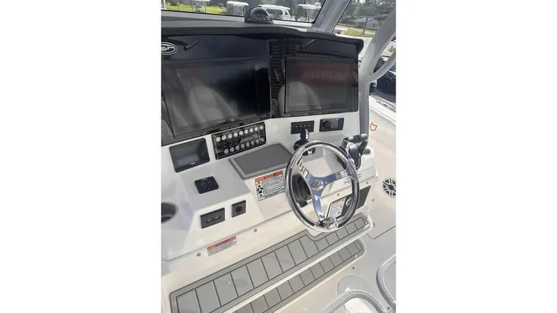 Slide: The Image of 2025 Sea Fox 328 Commander boat dashboard with dual screens and steering wheel. - 10
