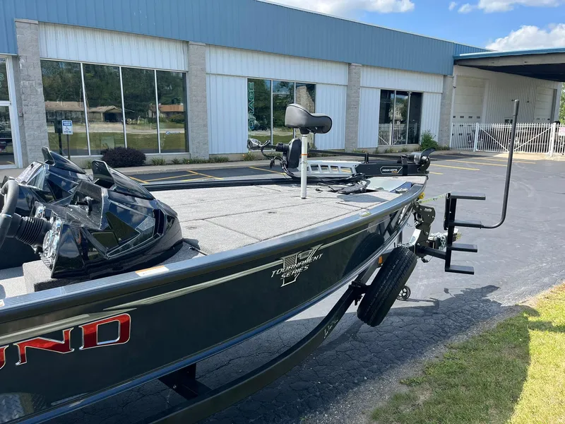 Slide: The Image of 2025 Lund 2075 Pro-V Bass XS boat parked outside a building. - 5