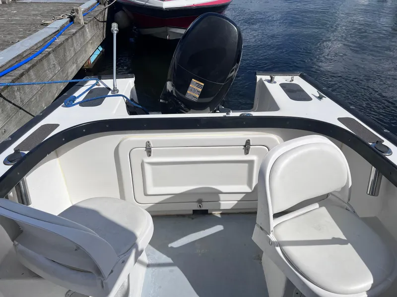 Slide: The Image of 1996 Seabreeze 19 Cuddy boat interior with seating and outboard motor. - 12