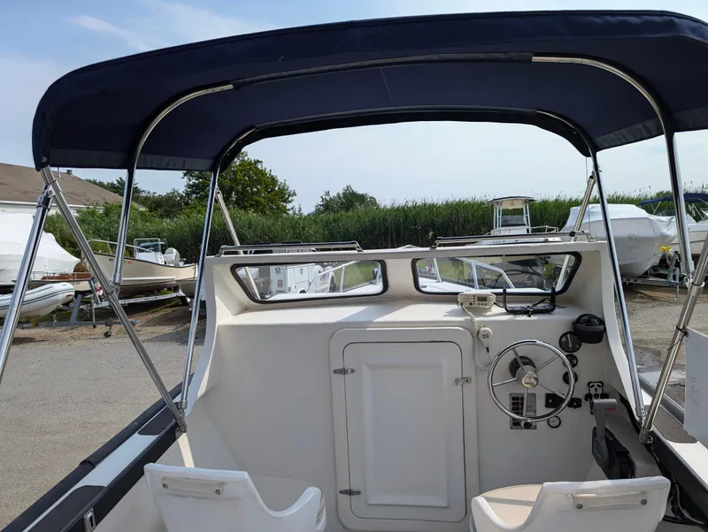 Slide: The Image of 1996 Seabreeze 19 Cuddy boat interior with steering wheel and canopy. - 2