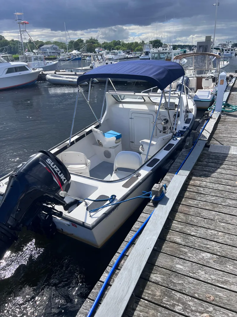 Slide: The Image of 1996 Seabreeze 19 Cuddy boat docked at a marina with Suzuki outboard motor. - 9