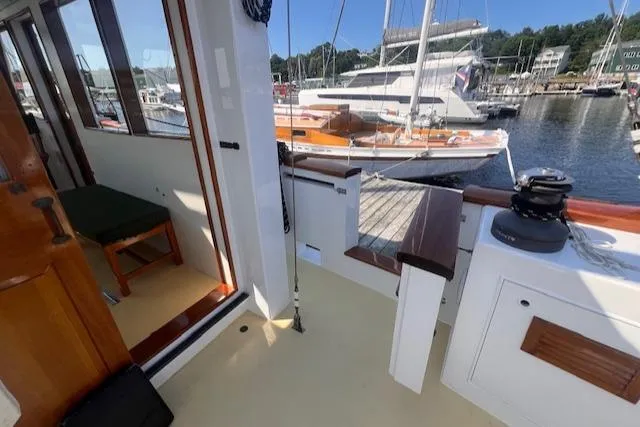 Slide: The Image of 1996 Custom Bolger PH Shoal-draft Ketch interior with marina view, featuring wooden accents. - 10