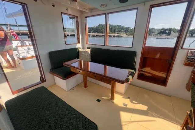 Slide: The Image of Interior of 1996 Custom Bolger PH Shoal-draft Ketch with seating and table, overlooking water. - 12
