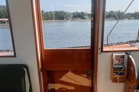 Slide: The Image of Interior view of 1996 Custom Bolger PH Shoal-draft Ketch with wooden door and water scenery. - 20
