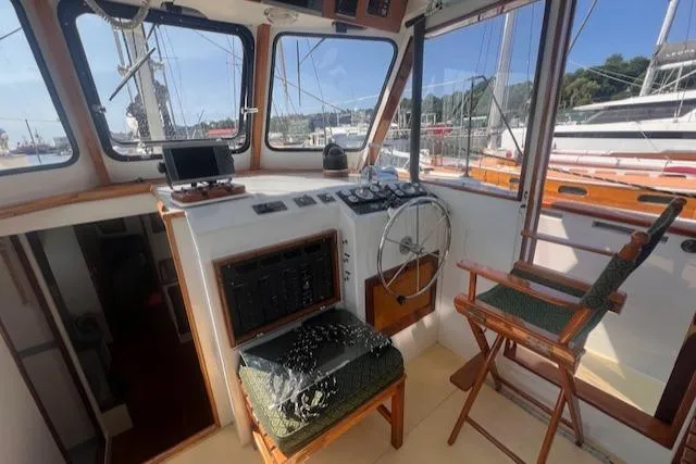 Slide: The Image of Interior of 1996 Custom Bolger PH Shoal-draft Ketch, featuring helm and navigation equipment. - 23