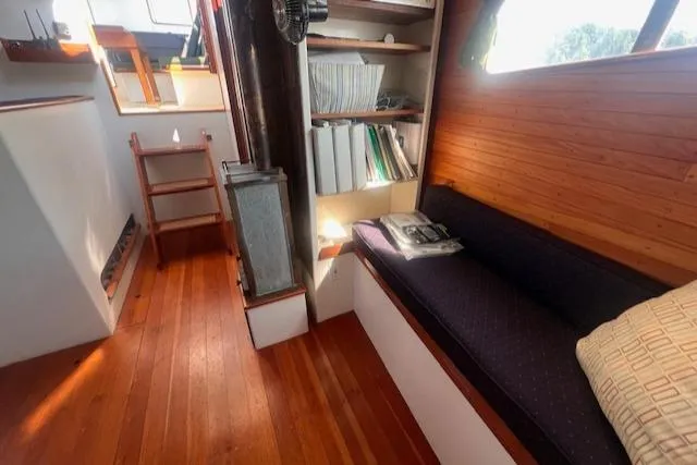 Slide: The Image of Interior of 1996 Custom Bolger PH Shoal-draft Ketch with wooden flooring and cozy seating. - 29