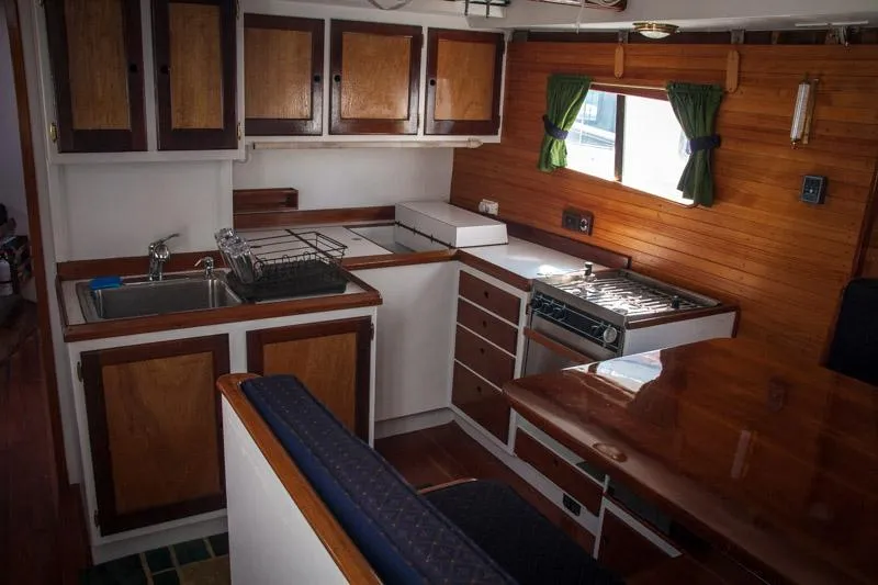 Slide: The Image of Interior of 1996 Custom Bolger PH Shoal-draft Ketch with wooden cabinetry and compact kitchen. - 3