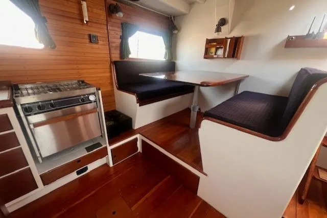 Slide: The Image of Interior of 1996 Custom Bolger PH Shoal-draft Ketch with dining area and stove. - 31