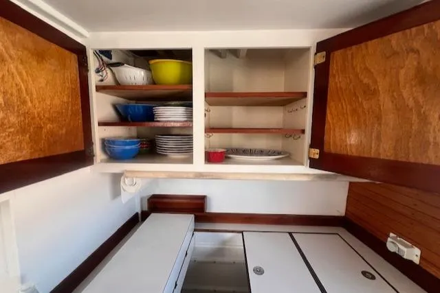 Slide: The Image of Interior of 1996 Custom Bolger PH Shoal-draft Ketch with open wooden cabinets. - 32