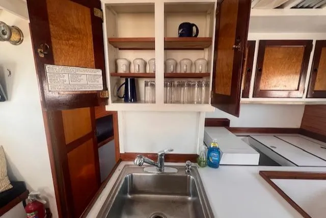 Slide: The Image of Interior of 1996 Custom Bolger PH Shoal-draft Ketch with sink and open cabinet. - 33