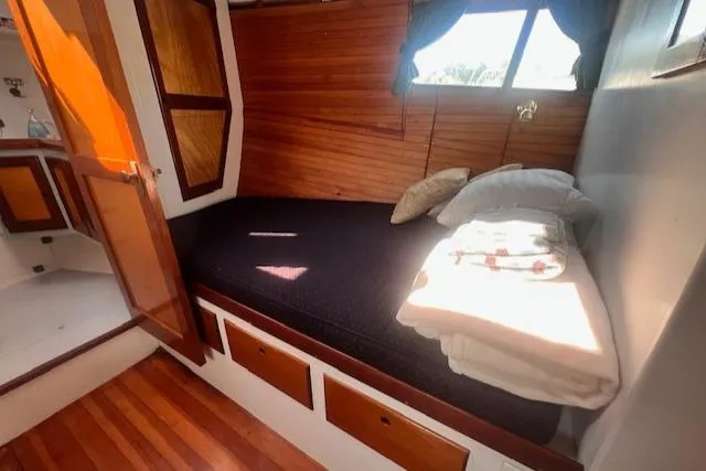 Slide: The Image of Cozy cabin interior of 1996 Custom Bolger PH Shoal-draft Ketch with wooden accents and bedding. - 36