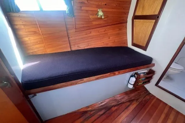 Slide: The Image of Cozy cabin interior of 1996 Custom Bolger PH Shoal-draft Ketch with wooden paneling and cushioned bench. - 37