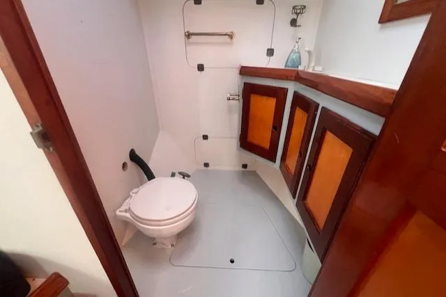 Slide: The Image of 1996 Custom Bolger PH Shoal-draft Ketch bathroom with wooden cabinets and marine toilet. - 38