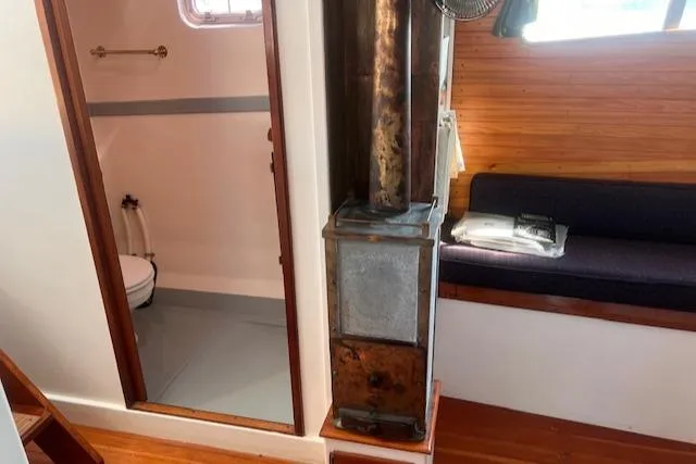 Slide: The Image of Interior of 1996 Custom Bolger PH Shoal-draft Ketch with wood stove and seating area. - 40