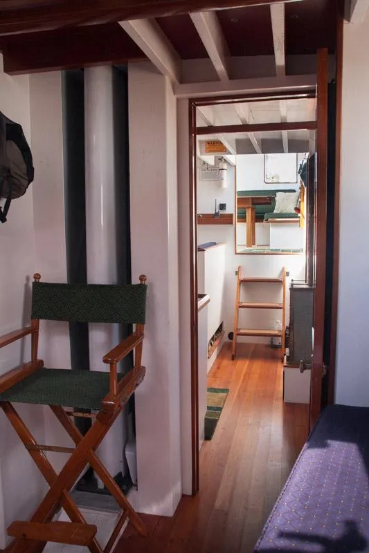 Slide: The Image of Interior of 1996 Custom Bolger PH Shoal-draft Ketch with wooden flooring and seating. - 6