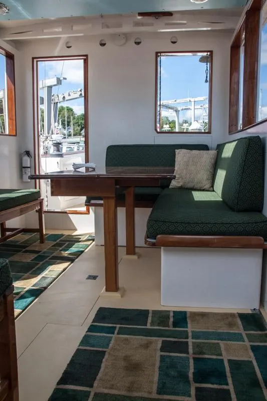Slide: The Image of Interior of 1996 Custom Bolger PH Shoal-draft Ketch with green seating and geometric rugs. - 9