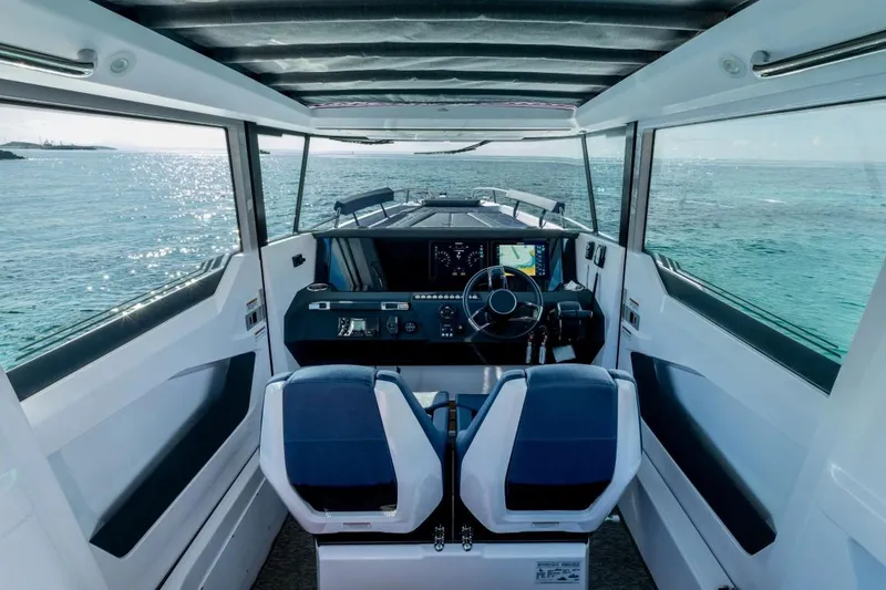 Slide: The Image of 2025 Axopar 29 XC Cross Cabin interior with ocean view, modern dashboard, and dual seating. - 5