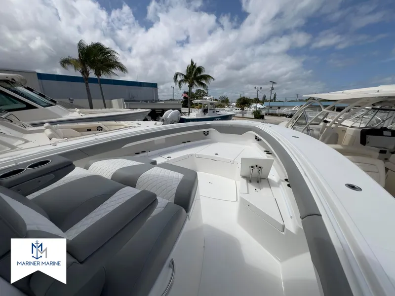 Slide: The Image of 2024 Regulator 37 boat with sleek seating, docked under a partly cloudy sky. - 11
