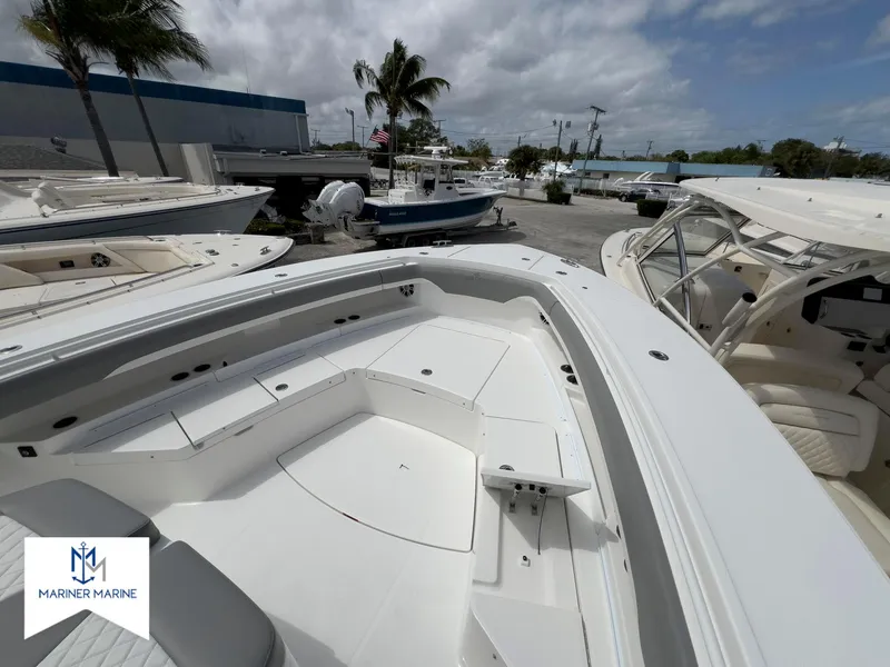 Slide: The Image of 2024 Regulator 37 boat with spacious deck, docked at Mariner Marine under a cloudy sky. - 12