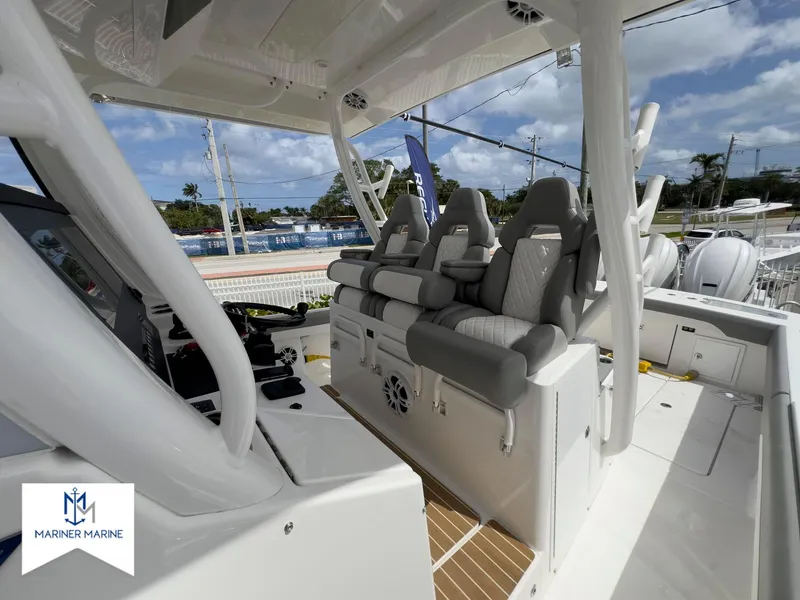 Slide: The Image of 2024 Regulator 37 boat interior with cushioned seating and helm, showcased by Mariner Marine. - 16