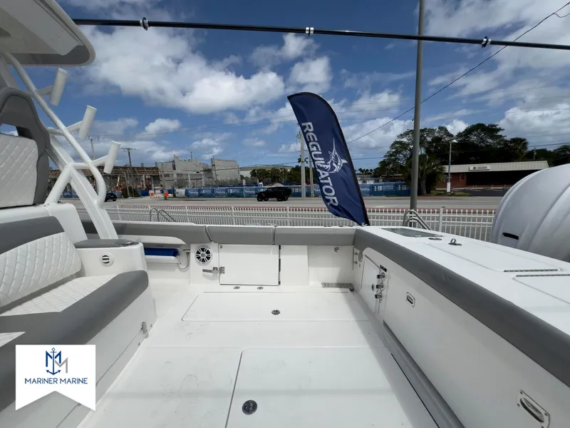 Slide: The Image of 2024 Regulator 37 boat deck with seating, Mariner Marine logo, and Regulator flag. - 20