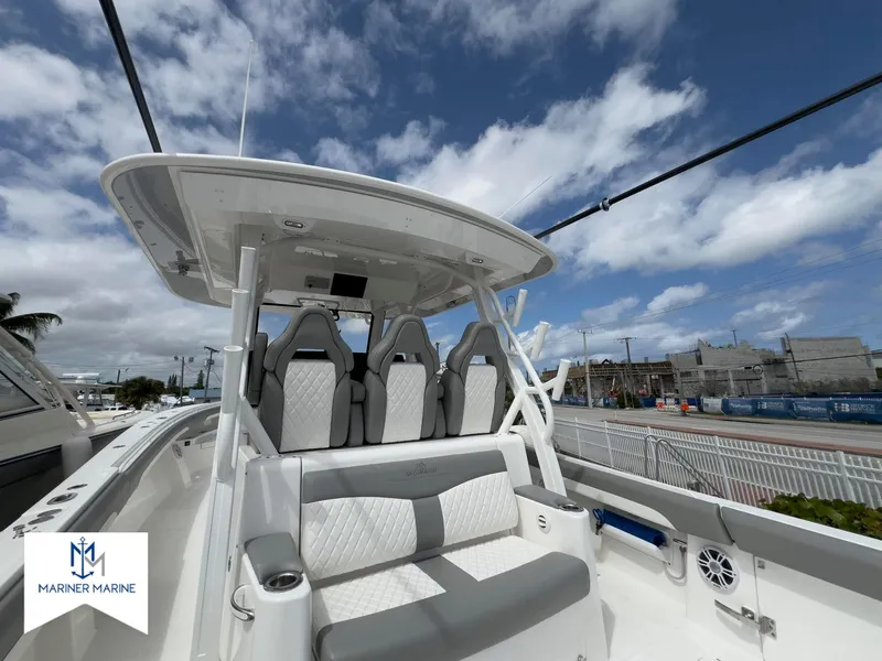 Slide: The Image of 2024 Regulator 37 boat with sleek seating and modern design under a blue sky. - 21