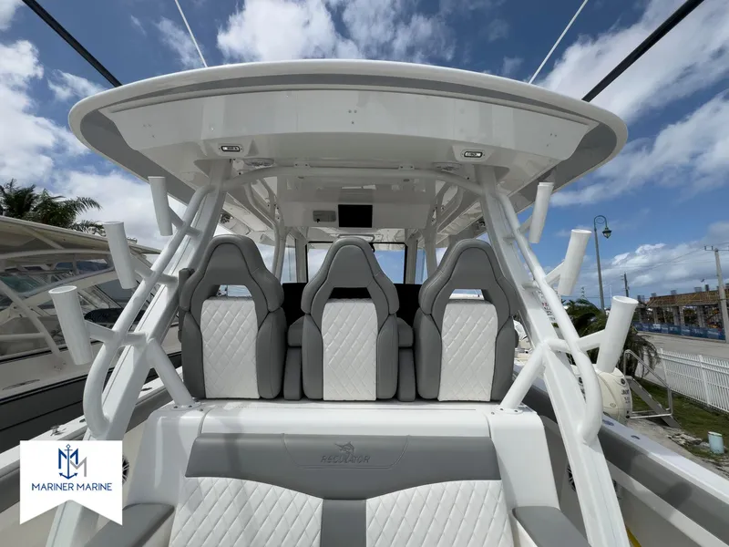 Slide: The Image of 2024 Regulator 37 boat interior with modern seating and sleek design under a clear sky. - 22