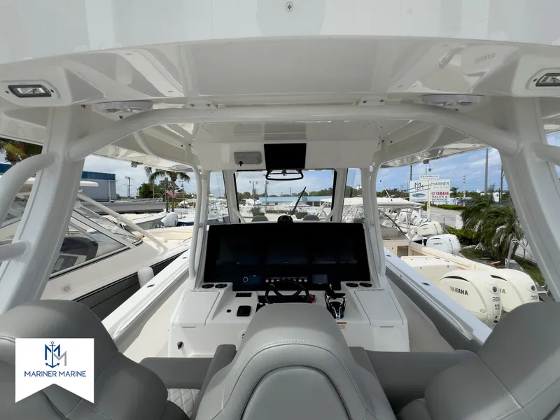 Slide: The Image of 2024 Regulator 37 boat cockpit with modern controls and seating at Mariner Marine. - 23