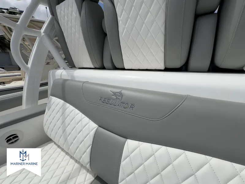 Slide: The Image of 2024 Regulator 37 boat interior with quilted seats and Mariner Marine logo. - 24