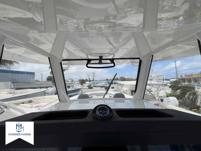 Slide: The Image of 2024 Regulator 37 boat cockpit view with compass, showcasing modern design and marina background. - 29