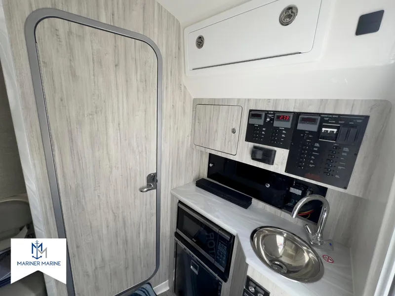 Slide: The Image of 2024 Regulator 37 boat interior with control panel, sink, and storage. - 35