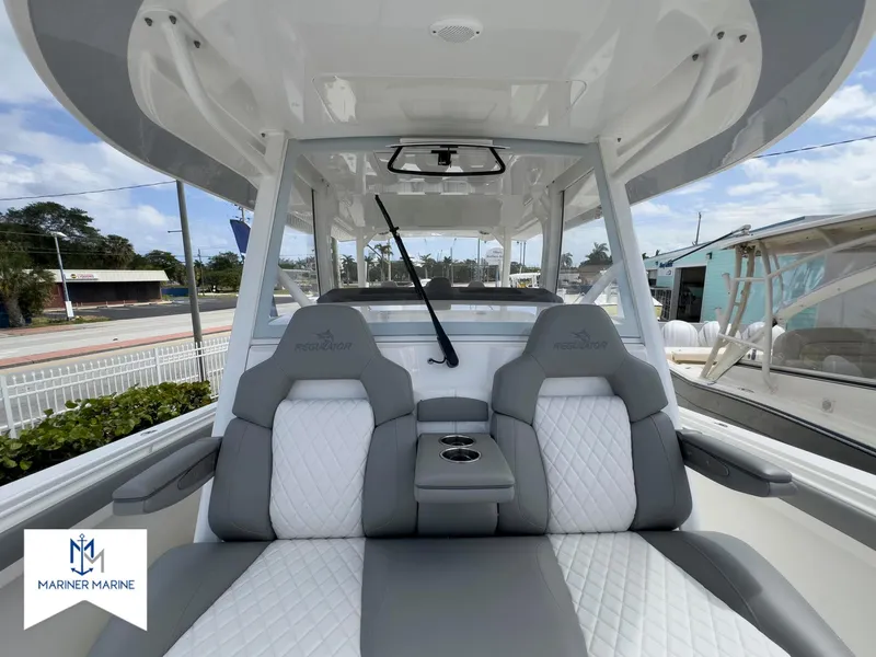 Slide: The Image of 2024 Regulator 37 boat interior with gray and white seating, cup holders, and Mariner Marine logo. - 38