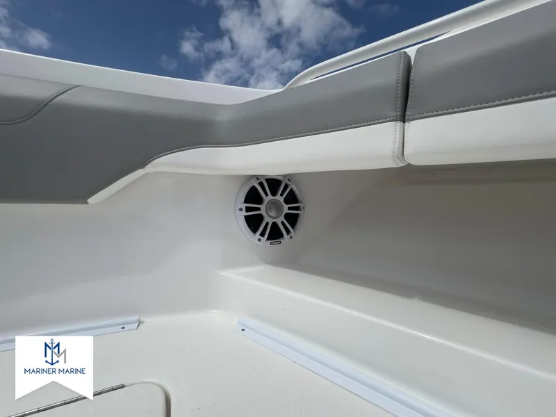 Slide: The Image of 2024 Regulator 37 boat interior with speaker, white and gray seating, blue sky background. - 41