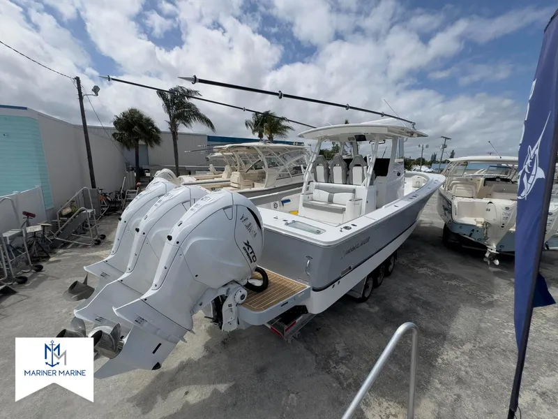 Slide: The Image of 2024 Regulator 37 boat with dual engines, docked at Mariner Marine under a cloudy sky. - 44
